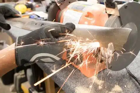 sharpening lawn mower blades process with a bench grinder